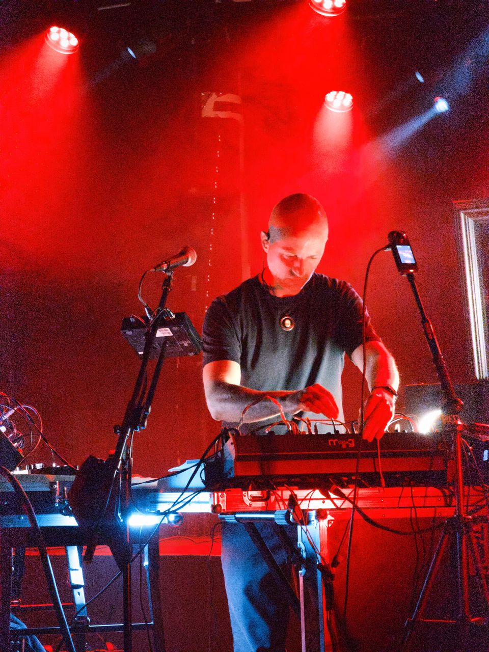OXSA sur scène à l'Undertown, face au public, les mains sur ses synthés sous les projecteurs rouges